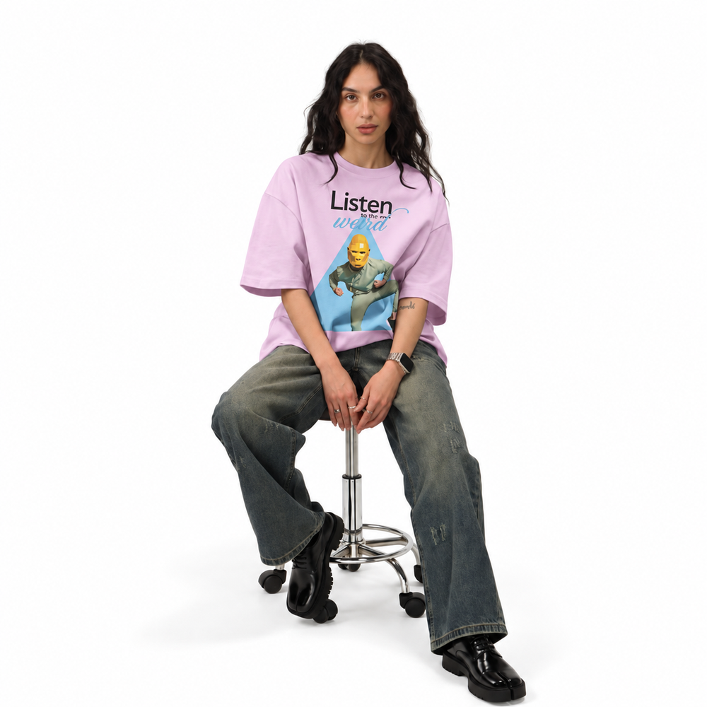 Model seated on a stool in the Ash Lilac oversized tee, full length